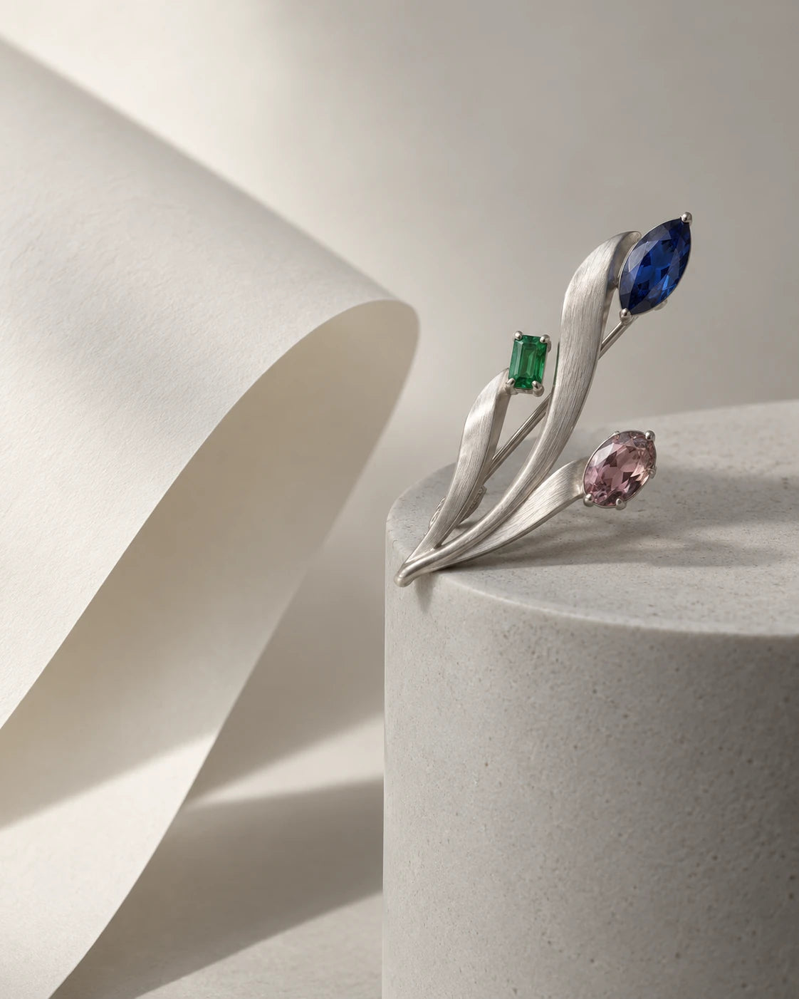 Original three-color sculptural ribbon brooch concept on a ceramic form