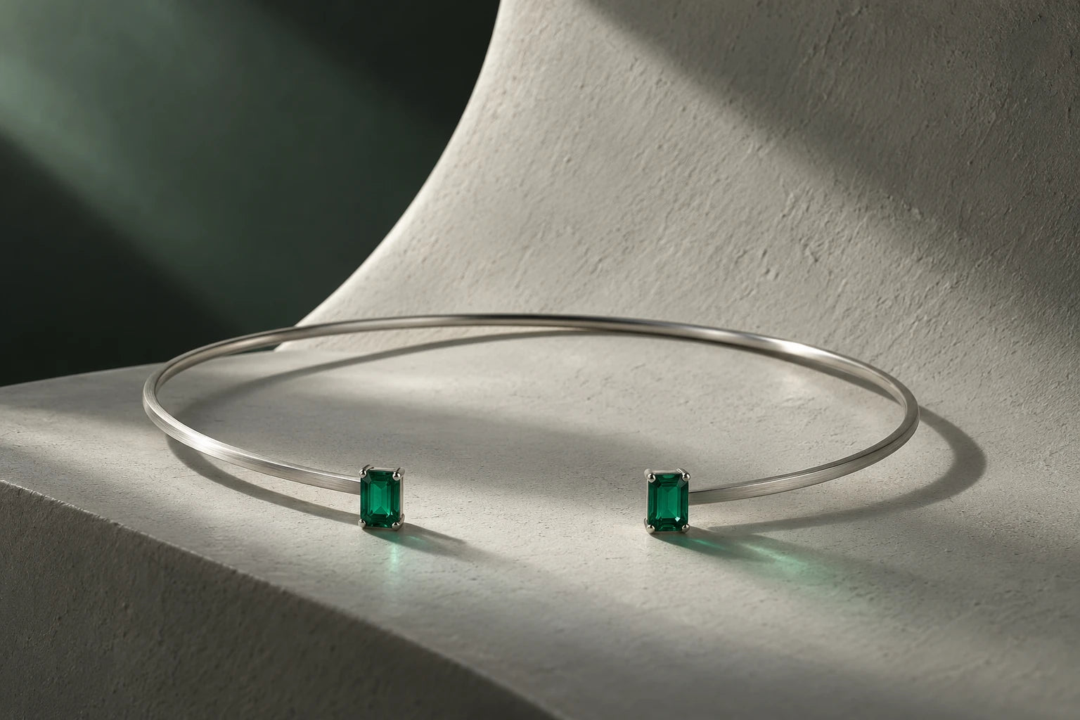 Concept emerald-green open torque on a minimal sculptural plane
