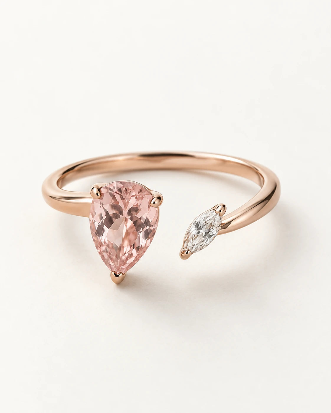 Asymmetric rose-gold ring with a pear-shaped pink gemstone and a small white marquise accent